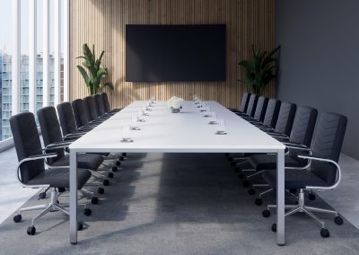 Black leather and chrome swivel base boardroom chairs around a large white boardroom table and wall mounted presentation screen