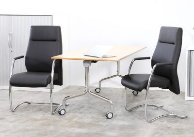 Black leather and chrome high back boardroom chairs with arms, flip top meeting table and Tambour door storage cabinets