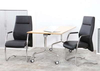 Black leather and chrome high back boardroom chairs with arms, flip top meeting table and Tambour door storage cabinets