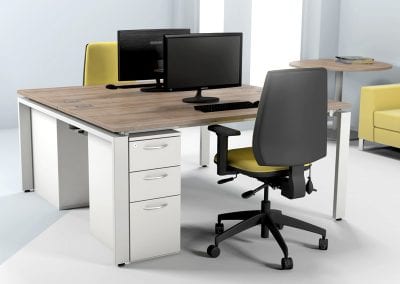 2 person back to back bench desks with 3 drawer under desk pedestal units, adjustable operator chairs, circular meeting table and designer sofa
