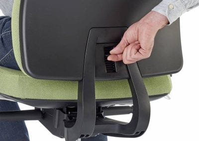 Close up detail photograph showing a person sitting on a posture task chair and controlling the back rest position