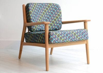 Natural wood frame occasional seat with bright patterned fabric seat cushions