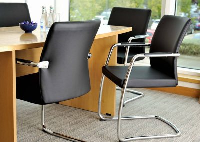 Black leather and chrome boardroom seating with barrel shape wood boardroom table