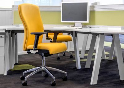 Operator task chairs with yellow fabric, chrome swivel base, adjustable back rest and arms, designer desks with divider screens and 3 drawer pedestal units