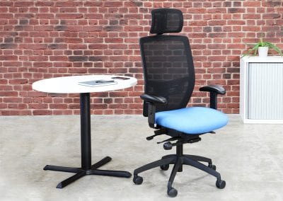 Mesh back adjustable posture operator chair with swivel base, arm and head rests, small circular meeting table and tambour door storage cabinet
