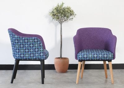 Purple and contrast pattern fabric occasional chairs with natural and black wood legs