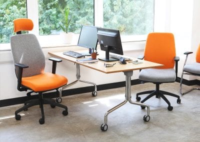 Adjustable posture chairs in operator task chair and meeting chair options, with swivel bases, arm rest and head rest, positioned around a flip top table