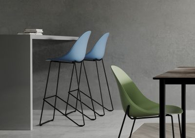 Photograph of two Skeet Summit stools with pale blue seats next to a grey table with green Skeet chair in the foreground