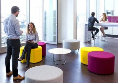 Yellow, pink and grey occasional stools wih a circular coffee table, white high bench table and wireframe high stools