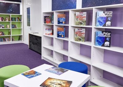 White height adjustable fully fitted wall mounted library shelves and matching coffee table with stools