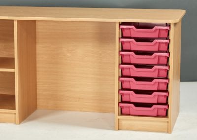Teacher desk with tray storage on one side and shelves on the opposite side