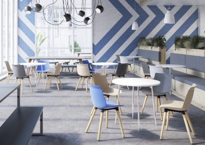 White circular breakout tables with chrome legs and multi colour dining style chairs with wooden legs