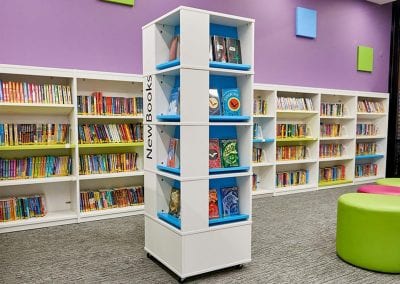 Square mobile tower book display unit with wall mounted fully fitted book display shelving and occasional seating