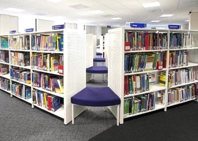 Modular metal library book shelves with integrated seating