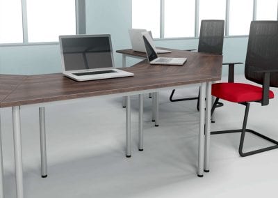 Modular dark wood veneer durable tables shown here in a meeting configuration with mesh backed meeting chairs