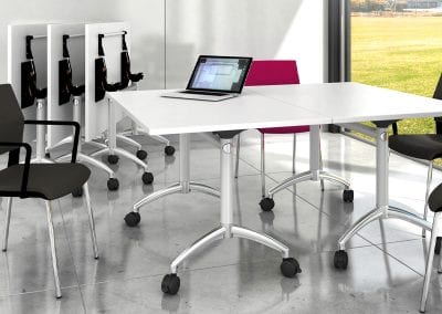 White tilt top tables with designer metal legs on castors with black stacking meeting chairs