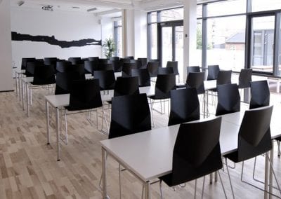 White rectangular dining tables with chrome legs and black angular dining chairs with chrome legs