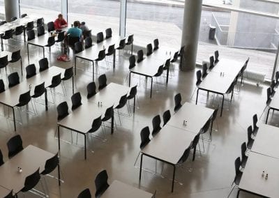 Rectangular dining tables with black metal legs and black stacking dining chairs