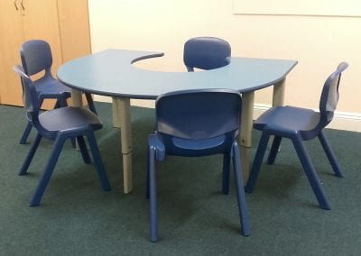 Height adjustable horseshoe shaped educational table with blue molded stacking chairs