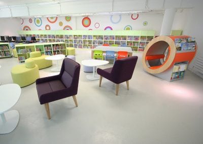 Large library space with fully integrated shelving, mobile shelving units, funky reading pod, coffee tables, computer workstations, stools and reading chairs