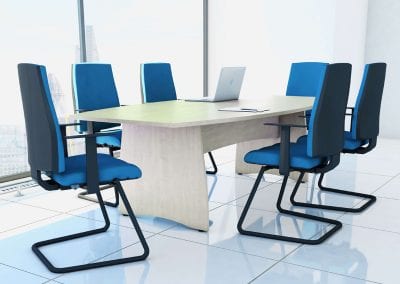 Barrel shaped light wood veneer meeting table with high back meeting chairs with arms and covered in blue fabric
