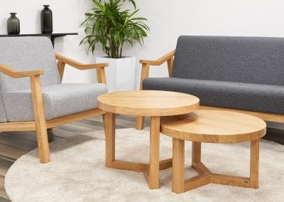 Nest of two circular wooden coffee tables with a chair and sofa with matching wooden frames