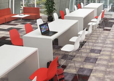 White high bench style tables with white and red high stools, and sofa seating area with coffee table