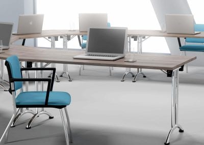 Wood veneer tables with chrome folding legs and teal and black meeting chairs