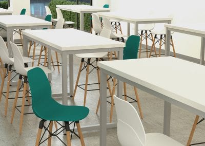 White top high bench tables with grey metal frame legs and Eiffel style high stools with white and green seats and wooden legs