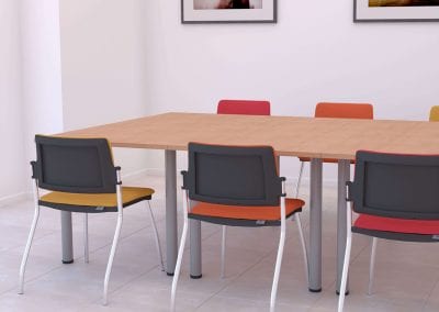 Solano Belize office meeting tables with wood veneer tops and chunky metal legs, shown here with stacking meeting chairs covered in different colour fabrics