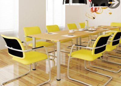 Two wood veneer meeting tables positioned together to create a long rectangular meeting table with yellow fabric covered meeting chairs
