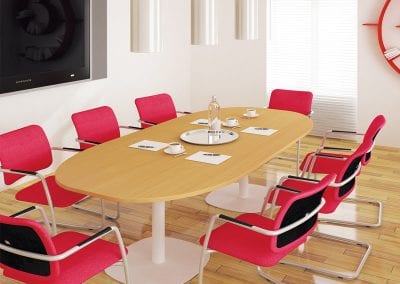Oval wood veneer boardroom table with white metal legs and red fabric covered meeting chairs