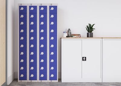 Group of four tall personal effects lockers with blue doors placed next to half height locking two door cabinets