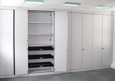 White finish floor to ceiling white office wall storage units with double doors and integral height adjustable shelves and trays