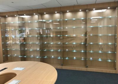 Floor to ceiling display cabinets with double glass doors, adjustable height glass shelving and integrated lighting