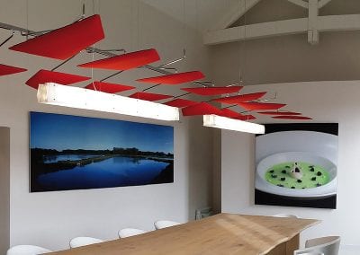 Statement acoustic screen panels attached to a chrome frame system and suspended over a board room table