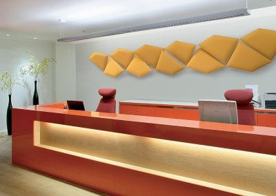 Wall mounted shaped acoustic screens available in a range of fabric options, seen here creating a feature wall in a reception area