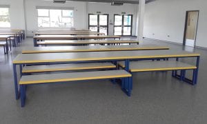 Colour coded metal framed tables and bence seating for educational and cateen environments